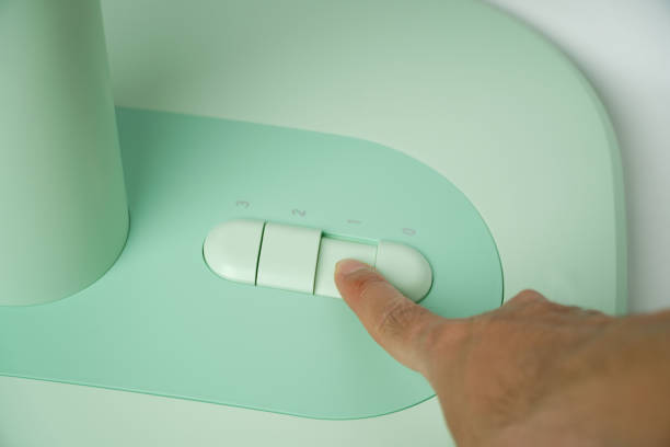 istock Hand presses the button on the control panel on the green electric fan 1490067559