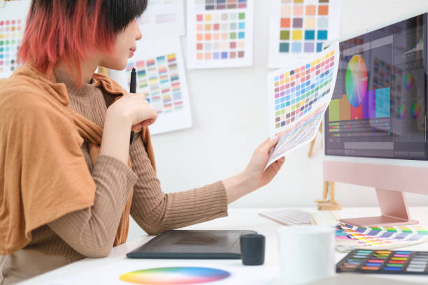 istock Asian female interior designer choosing color from samples for home interior design project in modern studio. 1490068089