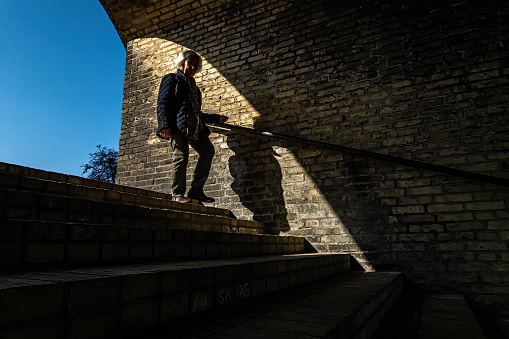 Copenhagen, Denmark April 17, 2023 A senior woman walks down steps  in the Bispebjerg distrcit