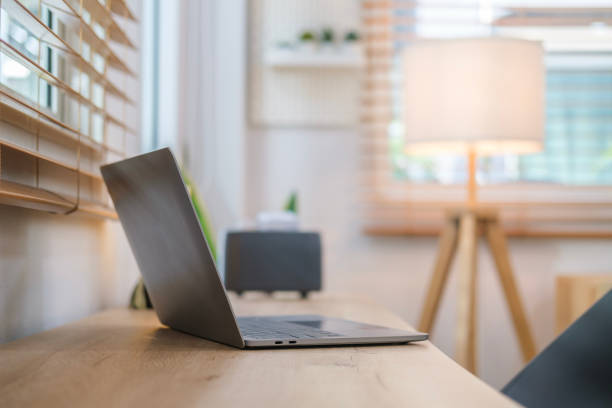 istock Side view of laptop computer on wooden table in modern home office interior. 1490068919
