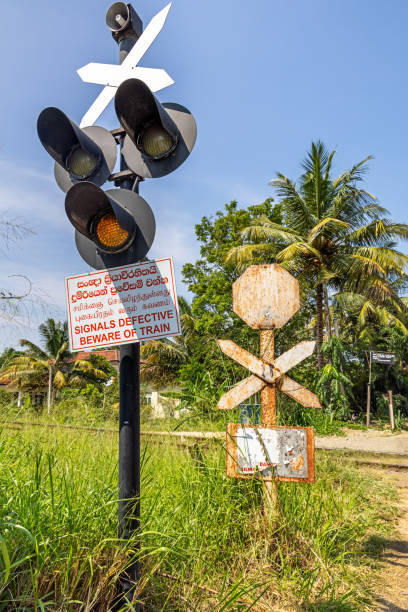 Negombo, Western Province, Sri Lanka - March 9th 2023: Signal at a railroad crossing with a poster warning people that it does not work