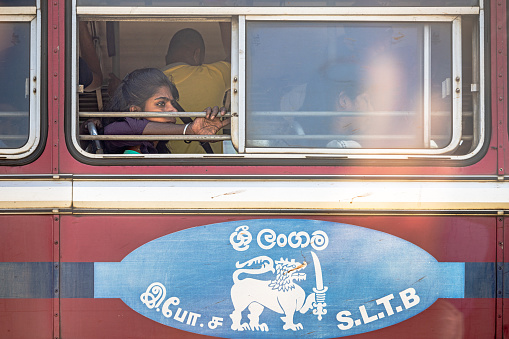 Negombo, Western Province, Sri Lanka - March 8th 2023:  Woman lost in her own thoughts seen through a open window in a long distance bus