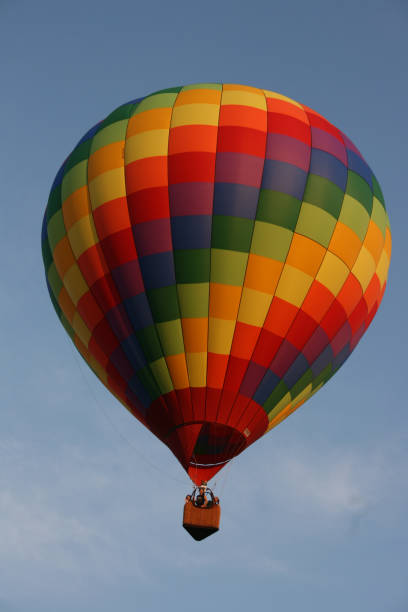 istock A hot air balloon with rainbow squares pattern flying in a cloudy sky 1490073422