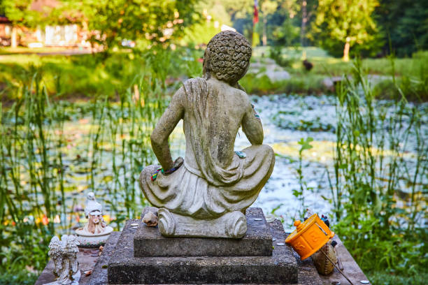 Image of A peaceful lily pond with Tibetan Mongolian Buddhist stone statue overlooking