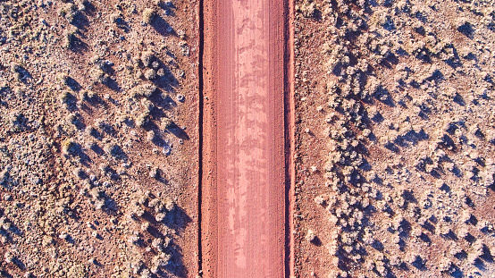 Image of Aerial looking down at red sandy desert road in plains