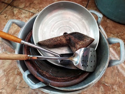 cooking utensils after being washed, there are pans, mortar, pots, silk, plates