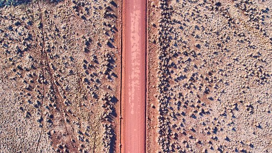 Image of Aerial view down at red sandy desert road in plains
