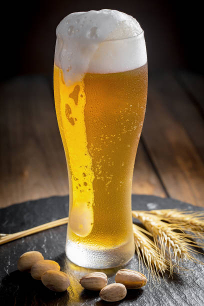 istock Light beer in a glass on a wooden background. 1490077168