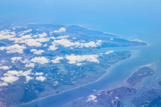 istock Airplane view of land with clouds covering 1490077268