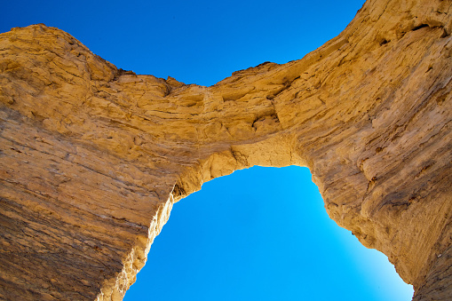 Image of Archway of natural white stone against blue sky