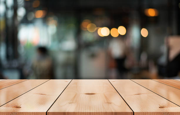 istock Empty wooden table top with lights bokeh on blur restaurant background. 1490077987