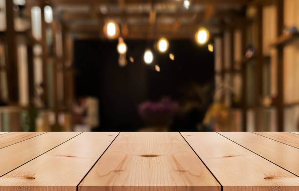 istock Empty wooden table top with lights bokeh on blur restaurant background. 1490077988
