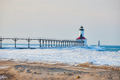 Amazing icy scenic harbor with lighthouse, Lake Michigan in Winter.