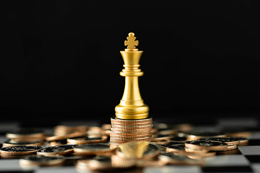 Stack of Coins with the Golden Chess king character to represent It's time to do money saving for retirement planning as concept.
