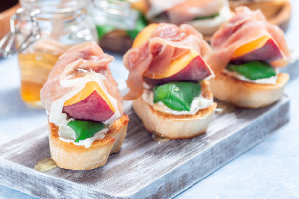 istock Prosciutto peach bruschetta, crostini with cream cheese, basil leaf, peach, prosciutto, horizontal 1490081890
