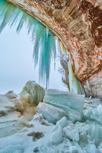 istock Broken giant icicle chunks in ice cave filled with icicles at entrance 1490082079