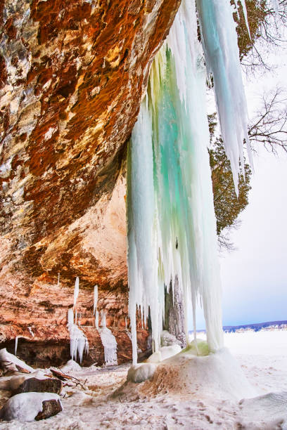 istock Cave opening in cliffs during winter with large icicles dangling 1490082495
