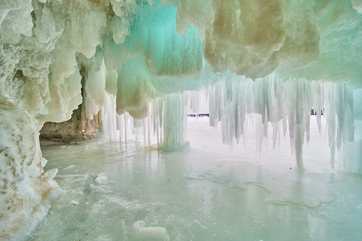 Image of Cavern on lake covered completely in blue ice and icicles