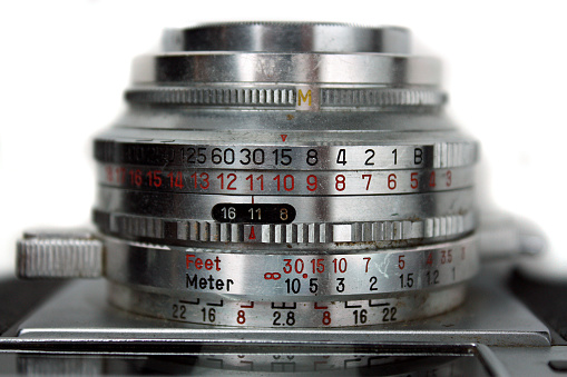 Image of Close up of Ricoh 500 camera lens with adjustment numbers in black and red