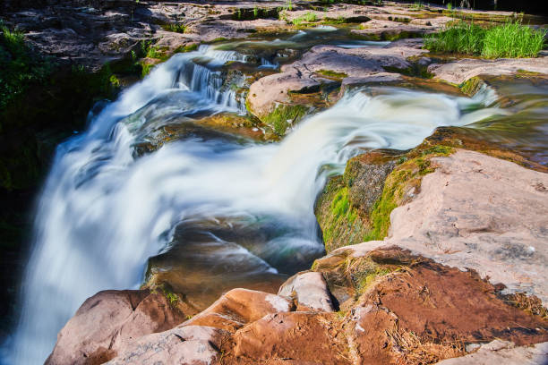 istock Close up of waterfall edge over mossy brown rocks 1490083648