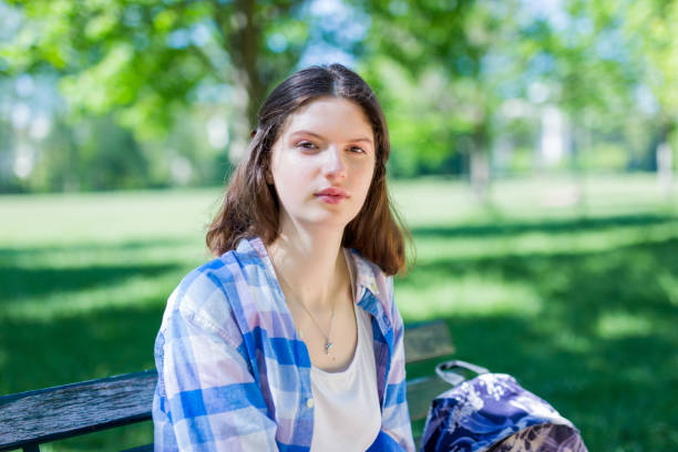 istock Young woman student sitting on a park bank 1490083726