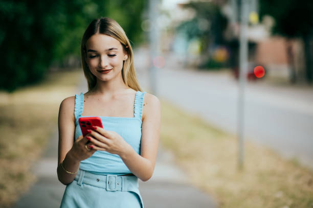 istock young woman on street using smartphone 1490085231
