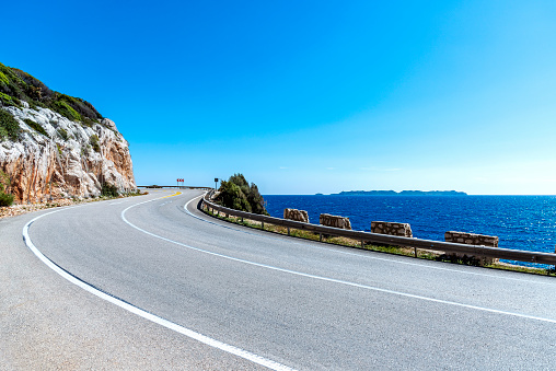 Close-up, winding road by mountain with sea and sky view. The road between Kaş (Kas) and Kalkan town in Turkey. Detail of the road.