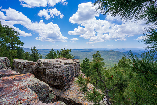 Dedicated and carefree male hiker, sitting on the rocky top of the mountain and enjoy the view