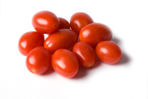 Pile or group of grape tomatoes shot on a white background