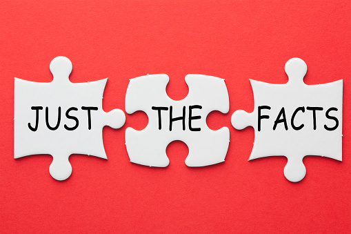 Just the facts text in 3 pieces paper puzzle on red background.