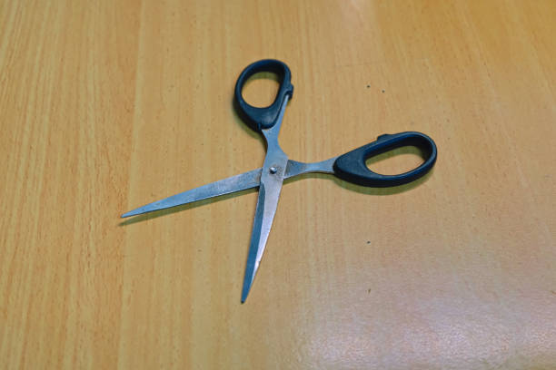 istock close up of scissors on a wooden table 1490088566