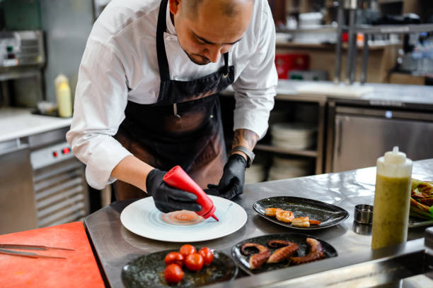 istock Professional chef garnishing an octopus dish in commercial kitchen 1490088603