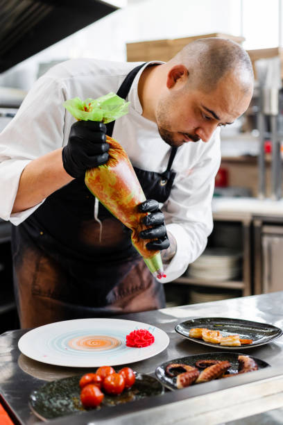 istock Professional chef garnishing an octopus dish in commercial kitchen 1490088618