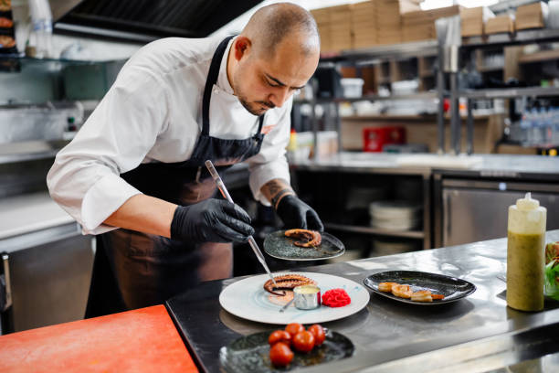 istock Professional chef garnishing an octopus dish in commercial kitchen 1490088620