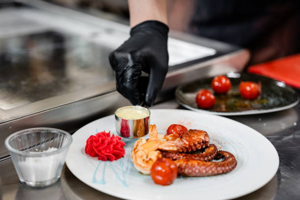 istock Professional chef garnishing an octopus dish in commercial kitchen 1490088624
