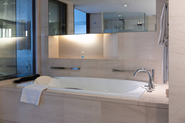 A contemporary bathroom featuring wall-hung toilets, a sleek glass shower, and elegant brown marble tiles, offering a luxurious and modern look.