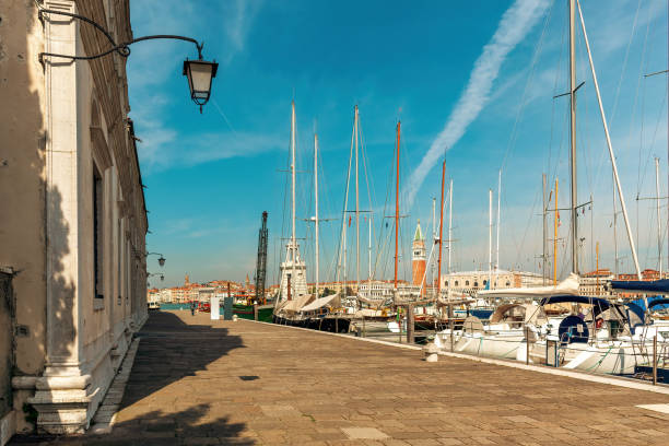 Yachts at small marina on San Giorgio Maggiore island in Venice, Italy. View of promenade along small marina with yachts on San Giorgio Maggiore island in Venice, Italy. san giorgio maggiore stock pictures, royalty-free photos & images