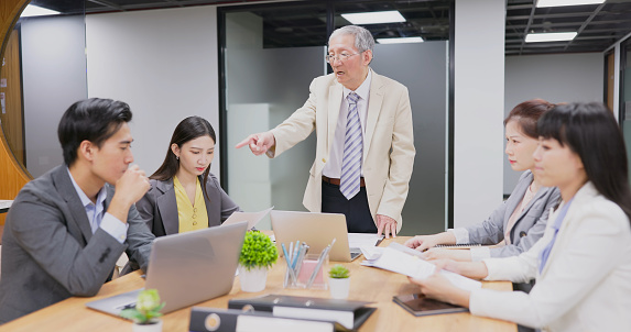 asian business people using laptop are having group meeting of company and senior manager is angry with male employee mistakes