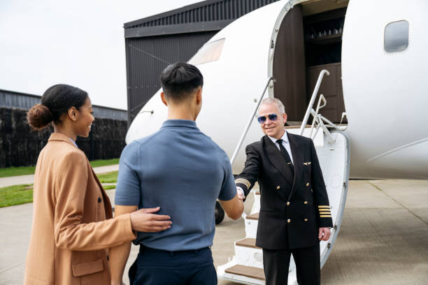 Private jet pilot greeting couple as they board aircraft