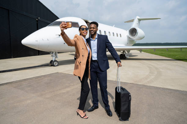 Young Black couple capturing memory of private jet travel