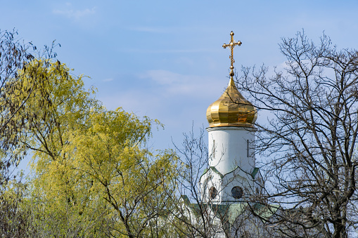 Church saint Nicholas with golden domes and place religion of orthodox christian. Built structure for prayer in modern city. Landscape with green park in middle of river. Monastyrsky island in Dnipro.