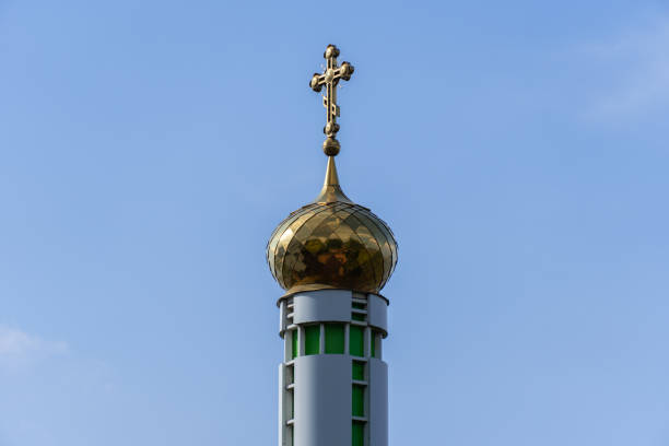 istock Tower with large golden dome and cross against blue sky. 1490104725