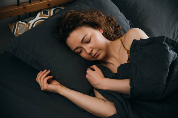 istock Tranquil young woman sleeping in bed Sleep on side 1490106099