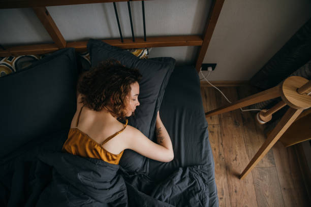 istock Woman sleeping on side on bed at home 1490106142