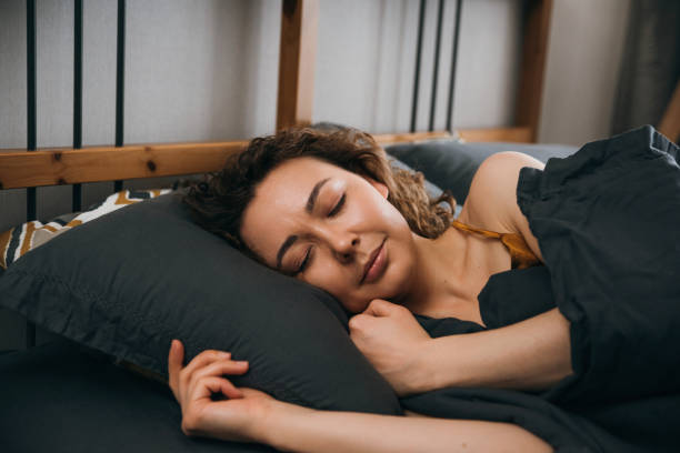istock Woman sleeping on side on bed at home 1490106144