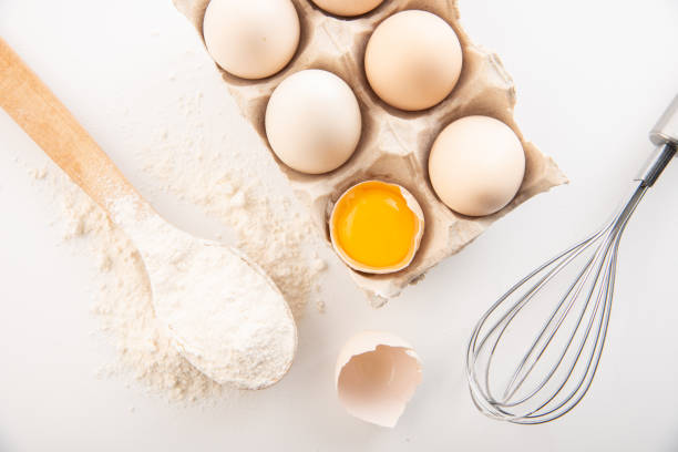 fresh chicken eggs with flour on a white background. cooking
