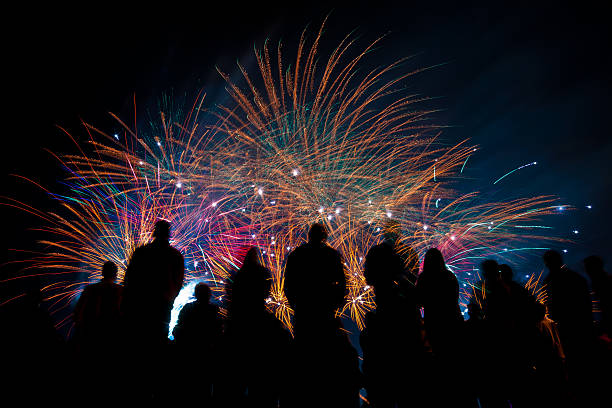 istock Big fireworks with silhouetted people in the foreground watching 149010791