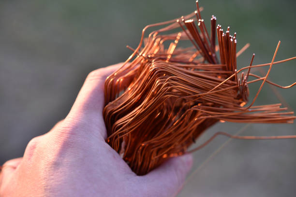 A bundle of copper wire in his hand. Copper scrap. Shiny red copper wire.