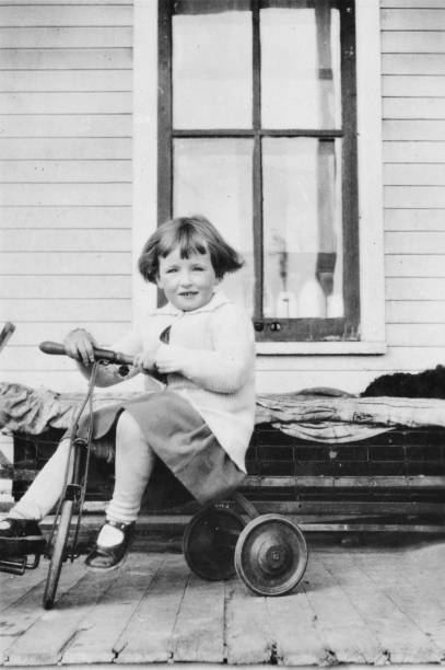 4 year old girl riding her tricycle at the city of Saskatoon in Saskatchewan, Canada. Vintage photograph ca. 1929.