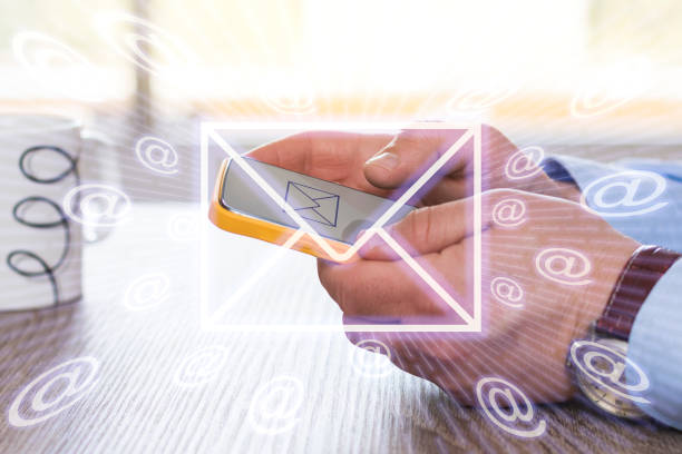 istock Close-up of hands sending a email with a mobile phone 1490117168